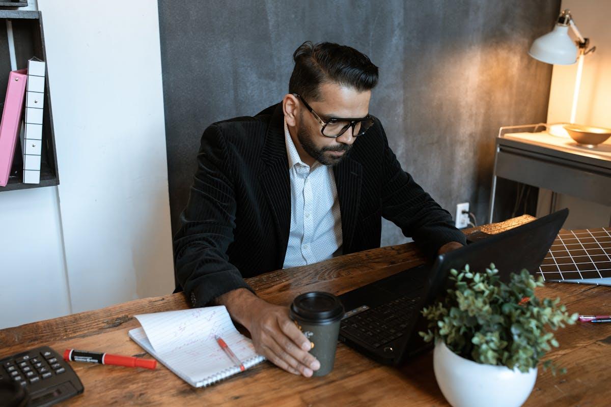Small business owner working on laptop with coffee