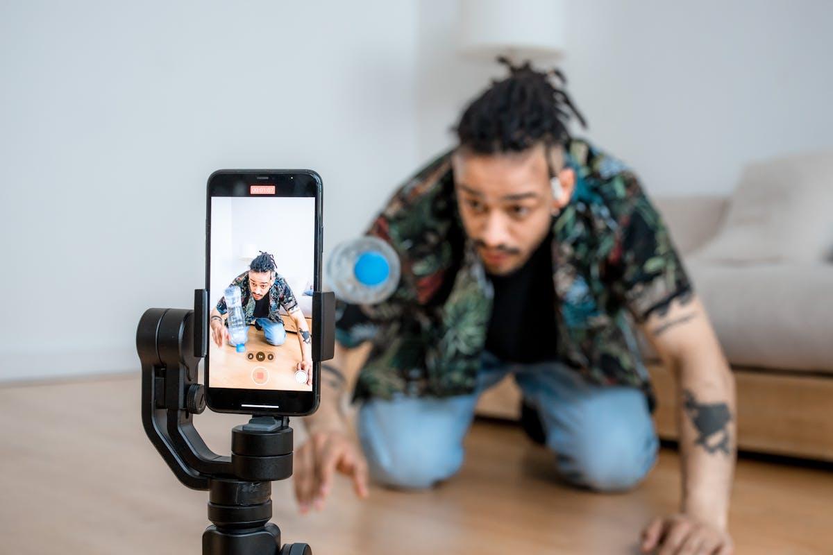 Man filming creative content with smartphone on gimbal indoors