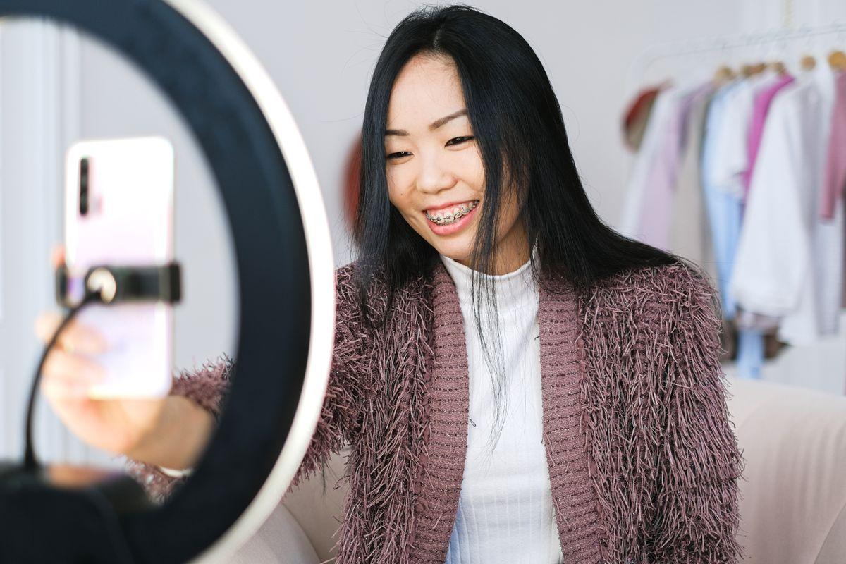 Influencer filming short-form video content on a smartphone with ring light