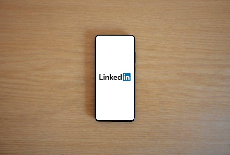 Pametni telefon s prikazano aplikacijo LinkedIn za profesionalno povezovanje in zaposlovanje
