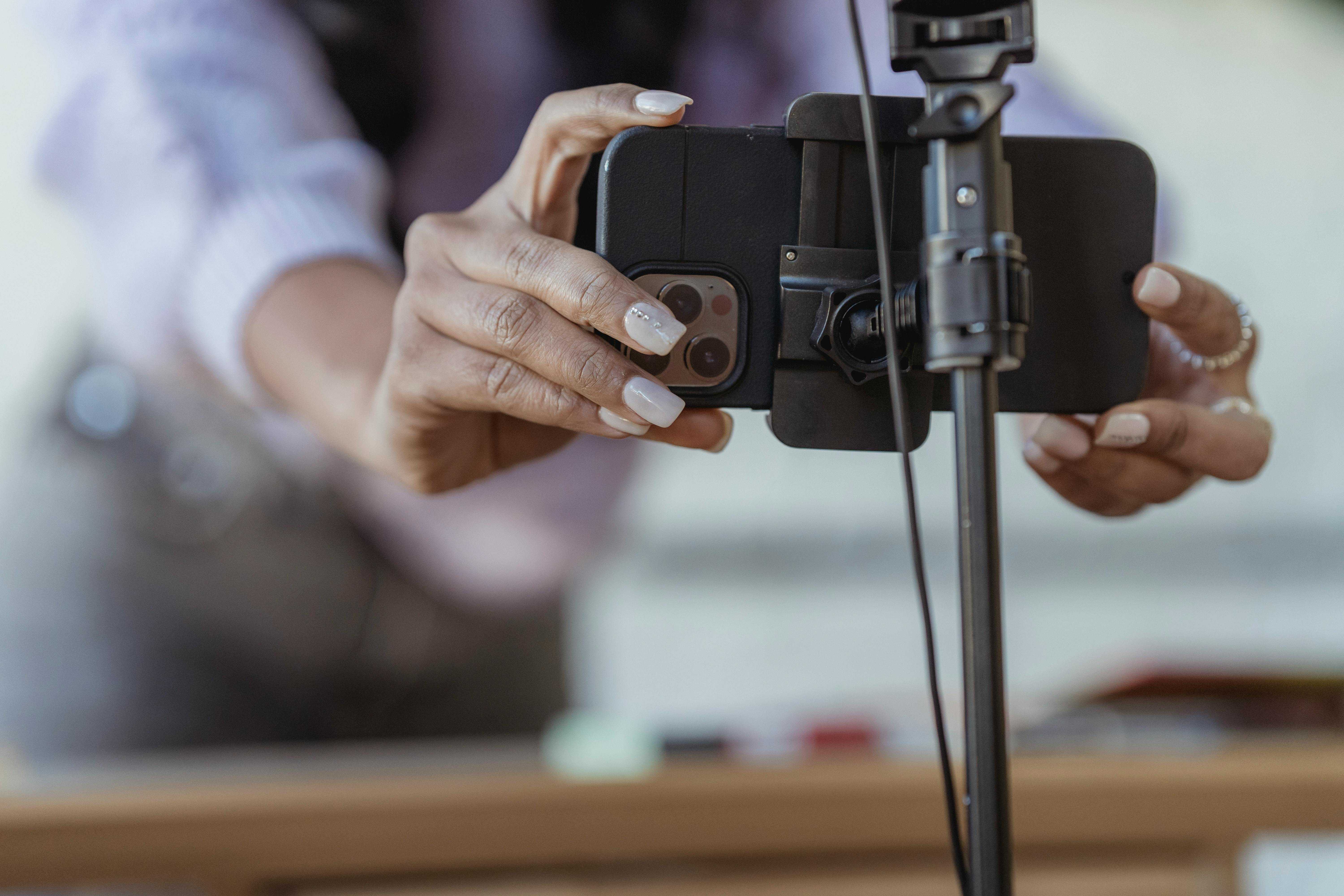 Woman setting up phone on tripod to record video content for social media Reels