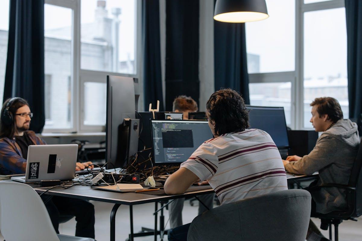 Team of developers working together on computers in modern office