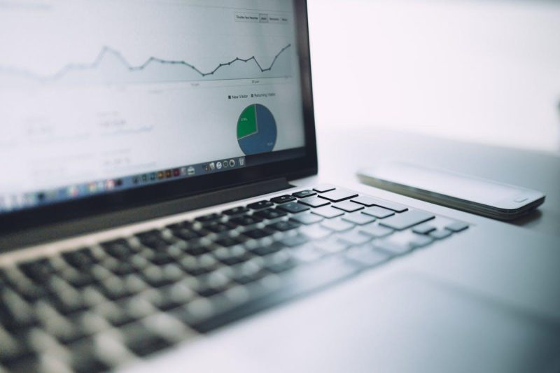 Laptop displaying analytics dashboard with charts and graphs for competitive analysis