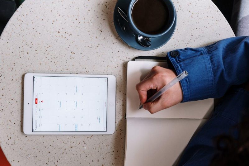 Overhead view of planning with a tablet notebook and coffee on a table