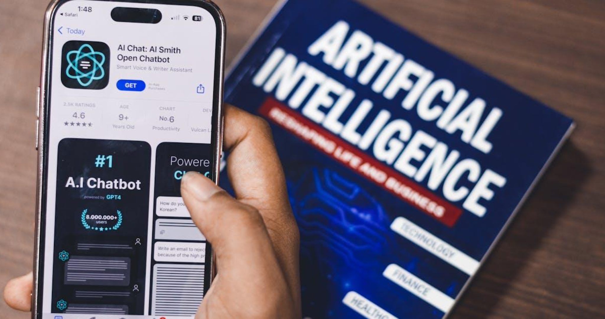 Smartphone displaying AI app alongside book on AI technology
