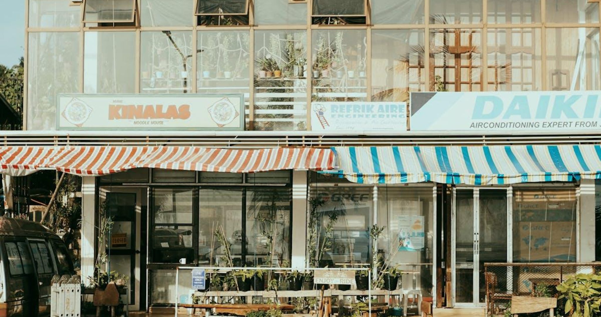 Charming street scene featuring local shops with colorful striped awnings and outdoor plants