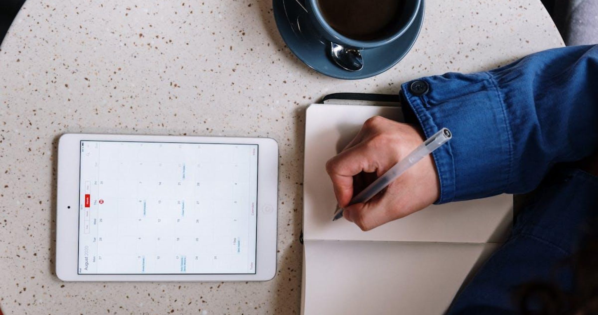 Overhead view of planning with a tablet notebook and coffee on a table
