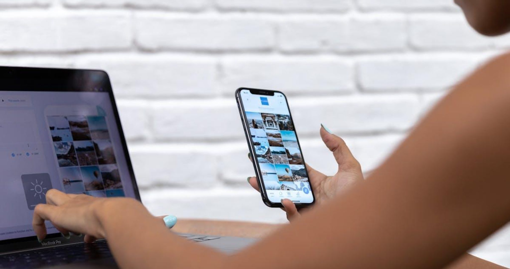 Woman working remotely on social media content using laptop and smartphone