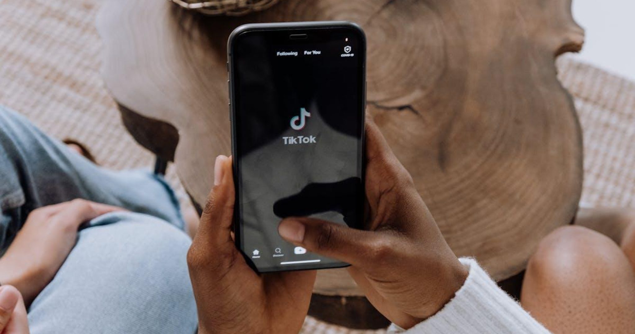 Close-up of a hand holding a smartphone displaying the TikTok app