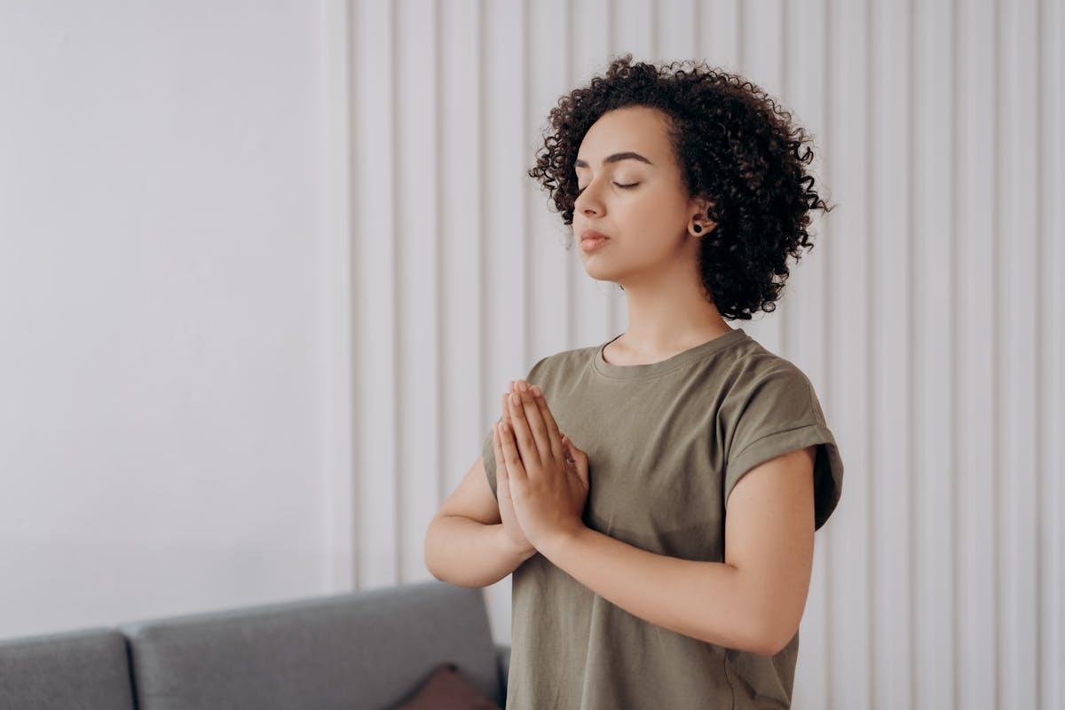 Mlada ženska meditira v zaprtih prostorih
