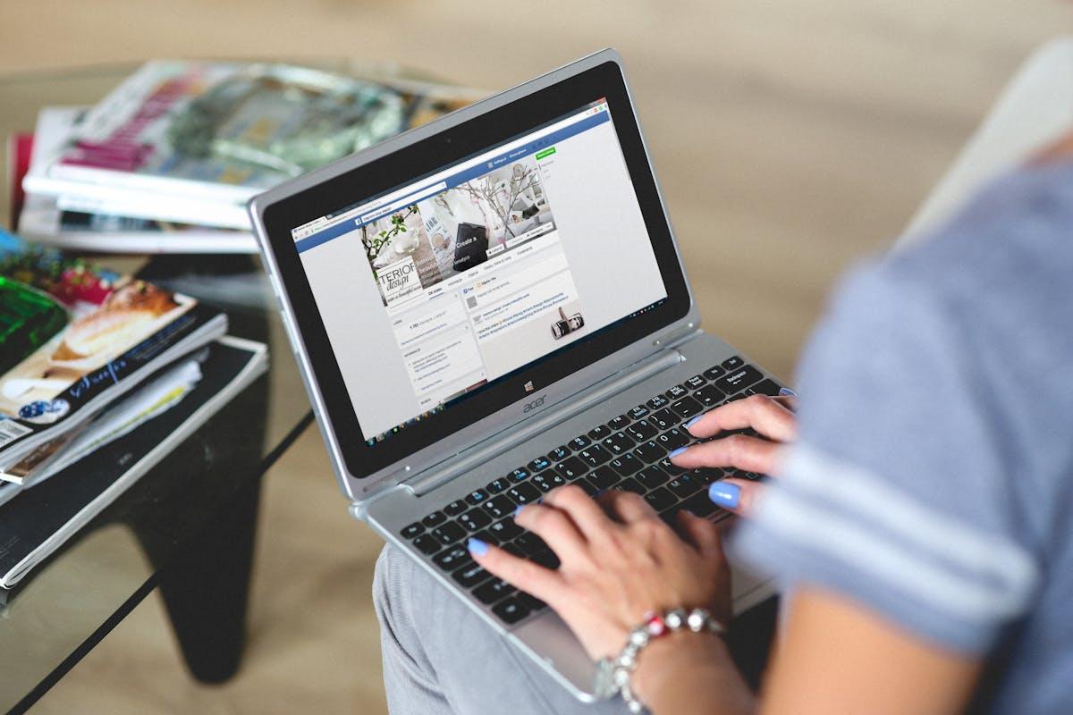 Woman typing social media captions on a laptop