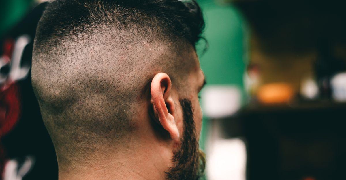 Rear view close-up of a man with a fresh haircut at a barbershop showcasing a sharp fade
