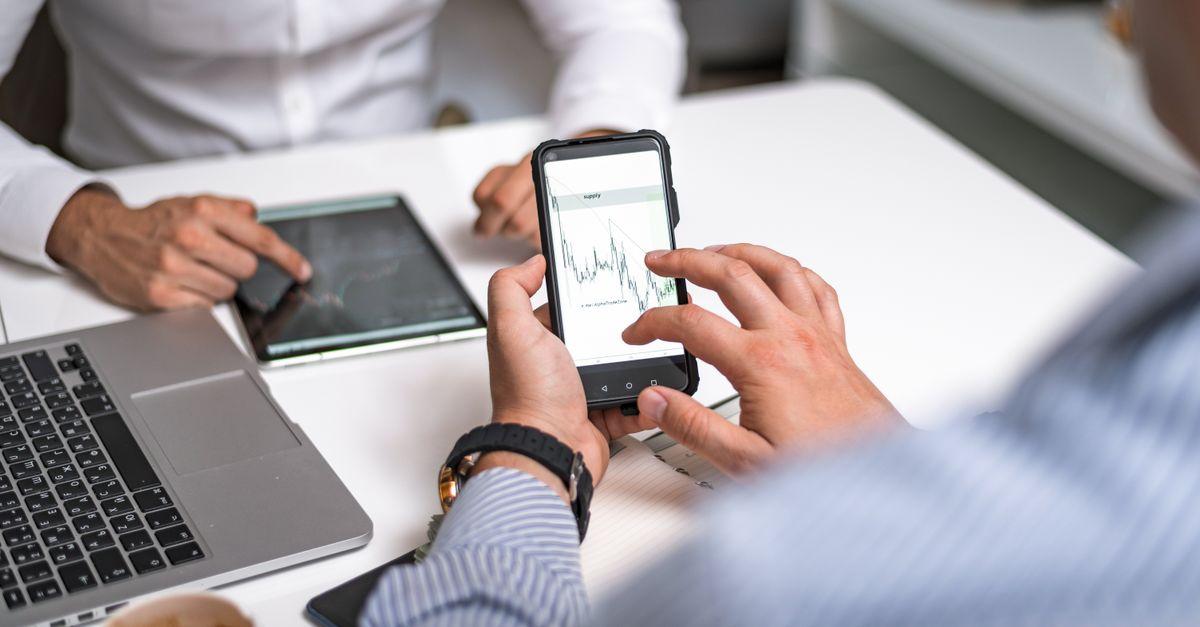 Two business professionals analyzing market trends on digital devices