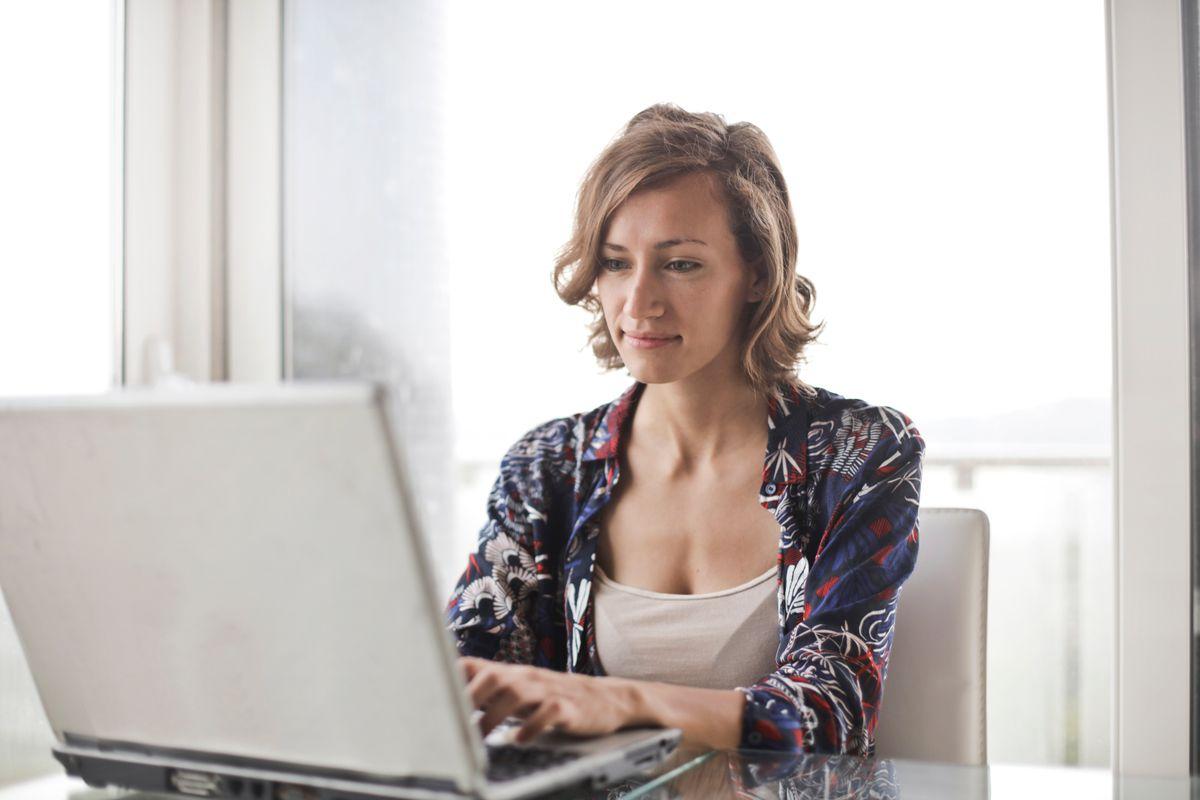 Business owner responding to customer messages on laptop