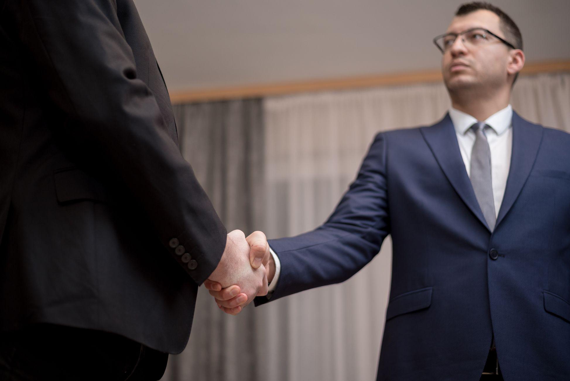 Two professionals shaking hands, symbolizing trust and partnership