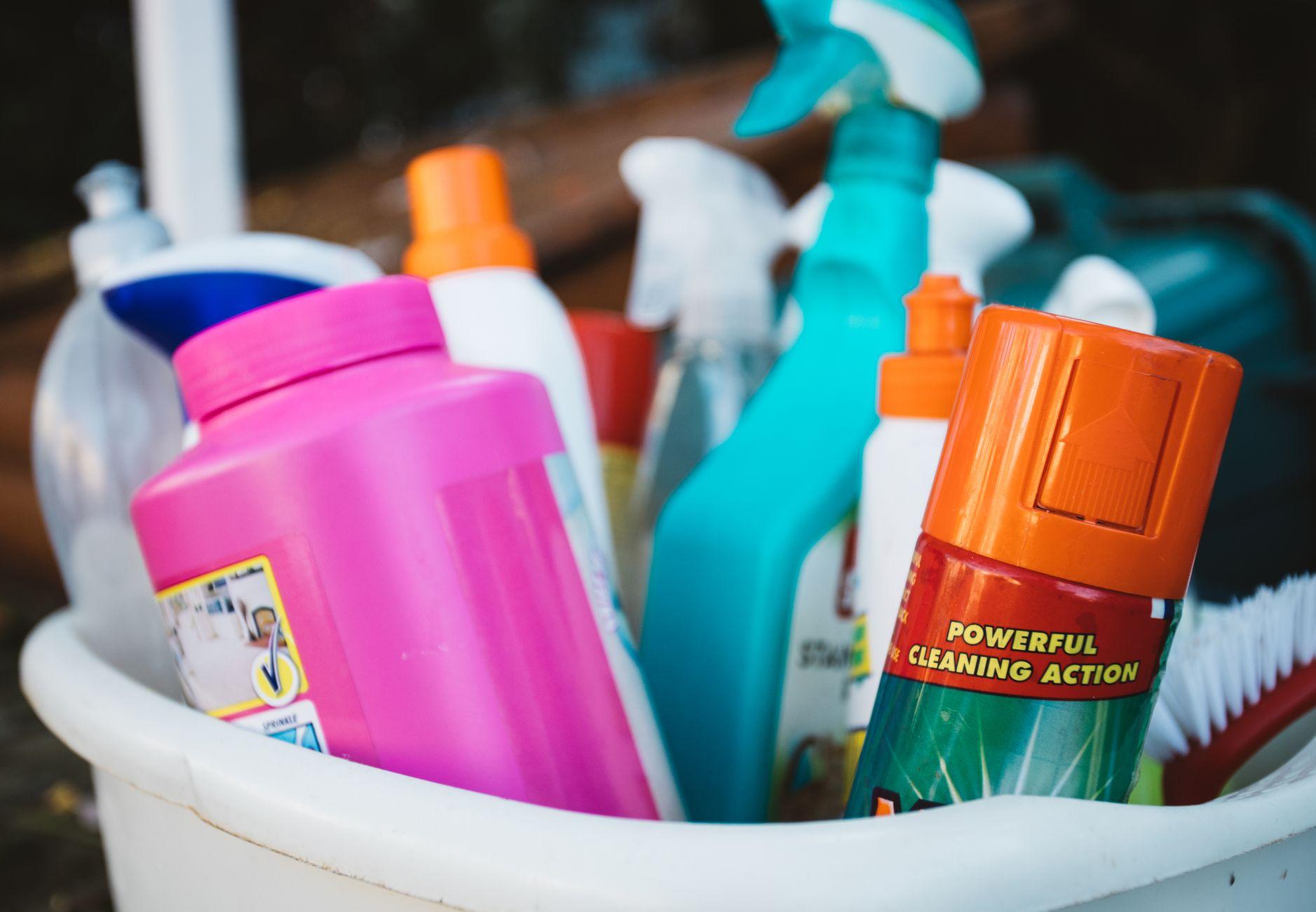 Collection of professional cleaning supplies and detergents in a bucket