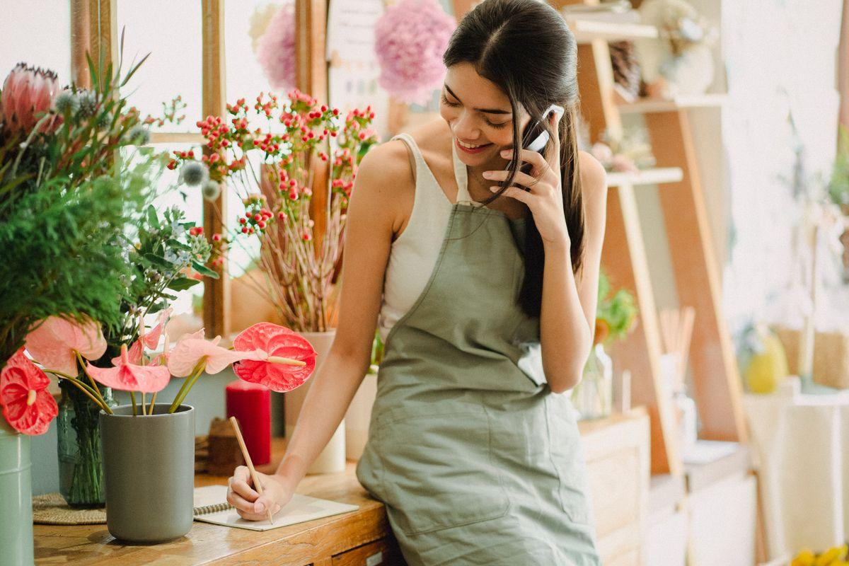 Small business owner answering phone in flower shop