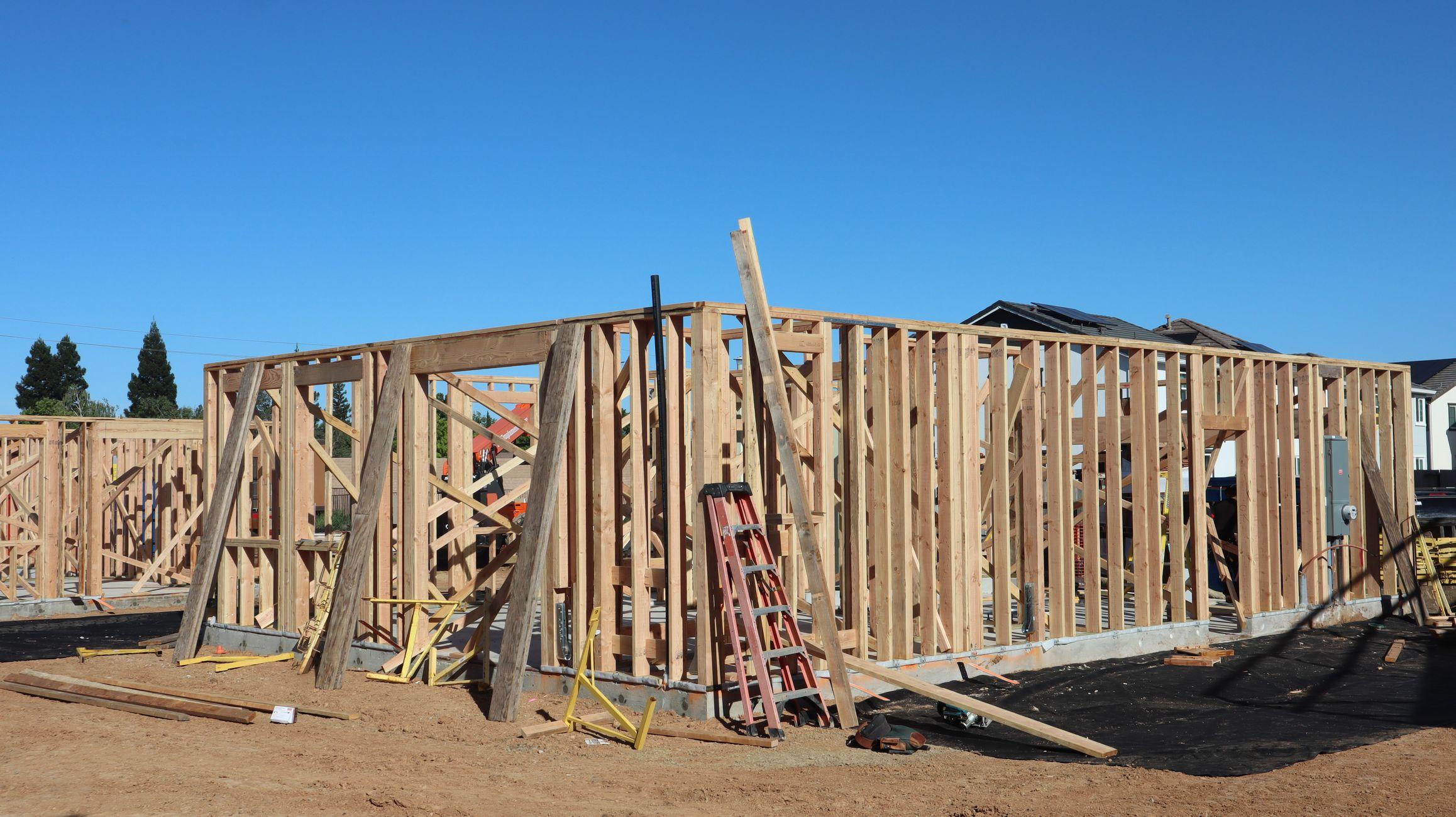 Construction site with workers building a house frame