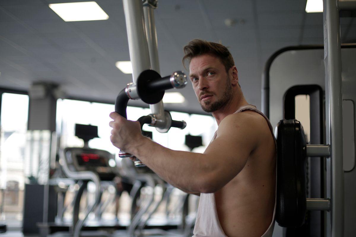Focused man working out in a gym, showcasing determination