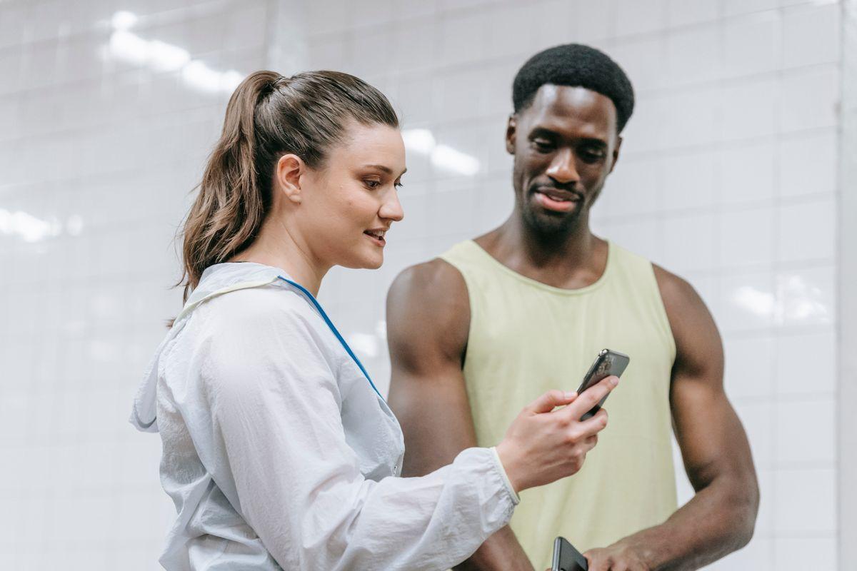 Trainer and member using a smartphone in a gym setting