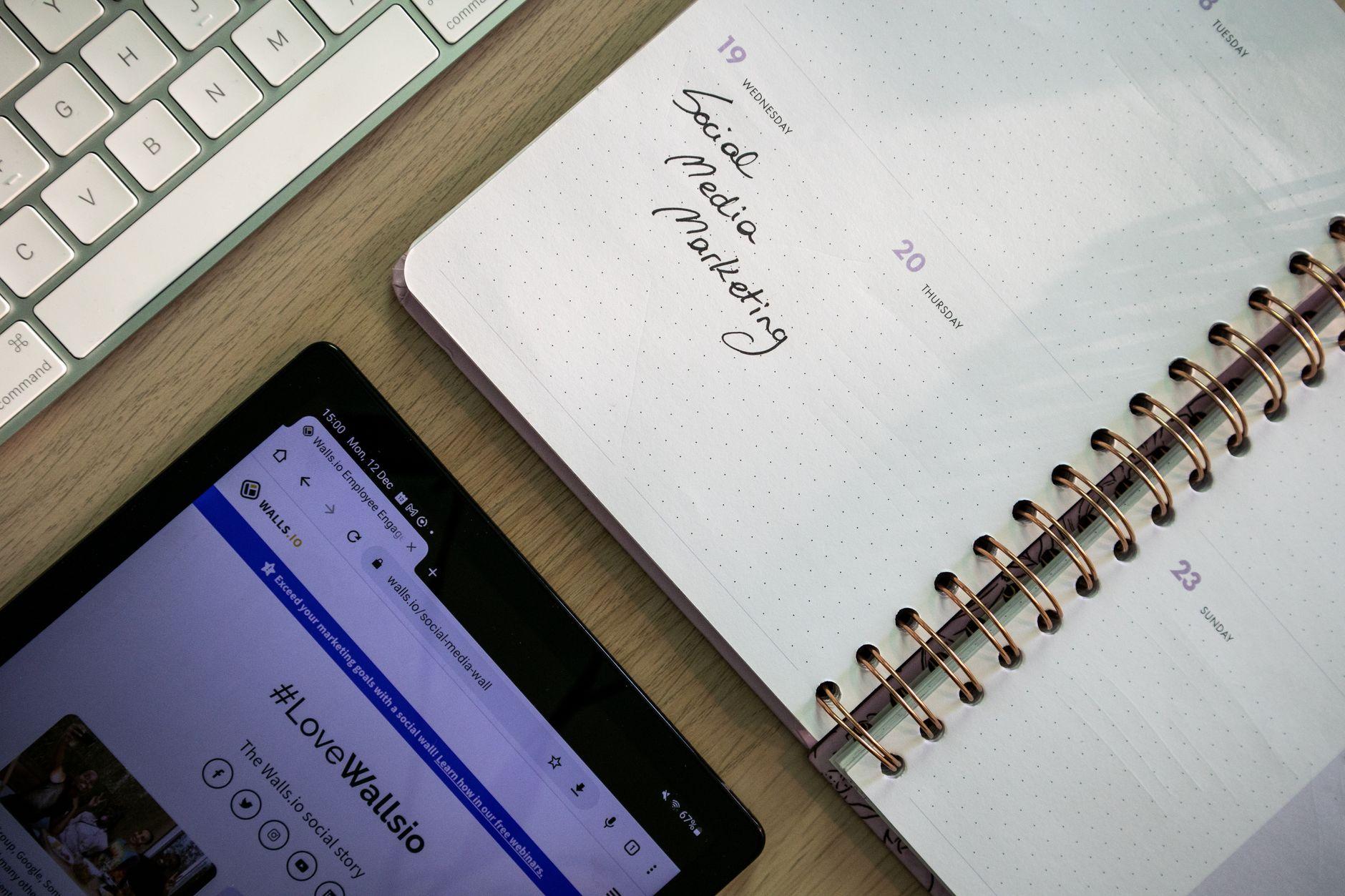 Notebook tablet and keyboard used for social media marketing content planning