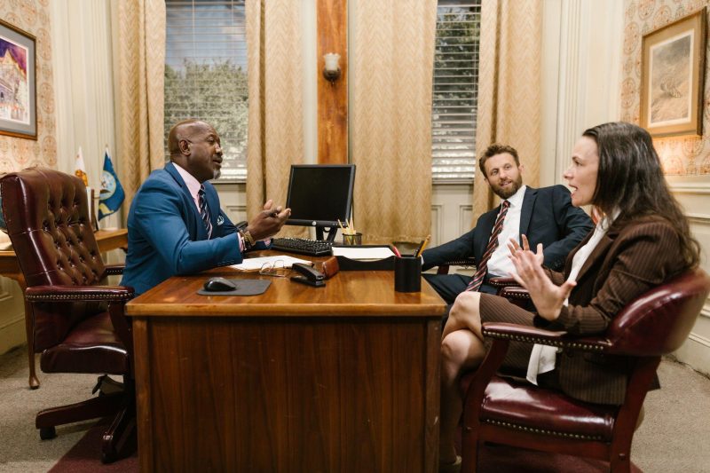Three attorneys discussing legal matters in a professional law office setting