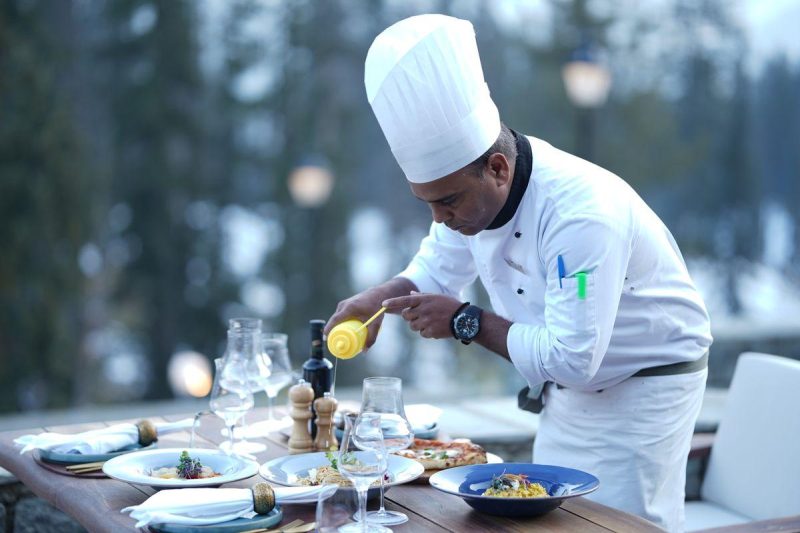 Chef carefully plating a gourmet dish in a professional restaurant kitchen