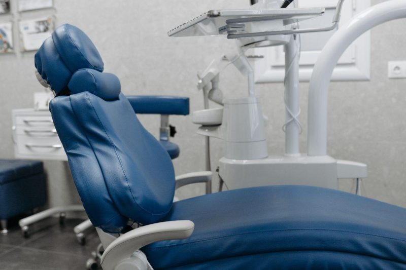 A clean dental office with state-of-the-art equipment and a blue dental chair, ready for patients