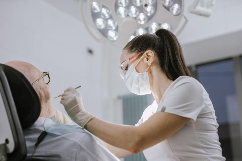 Female dentist working on a patient in a modern dental office with bright lighting