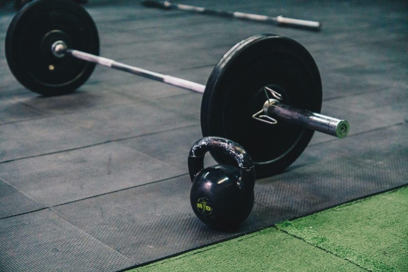 Barbell and kettlebell on gym floor for strength training
