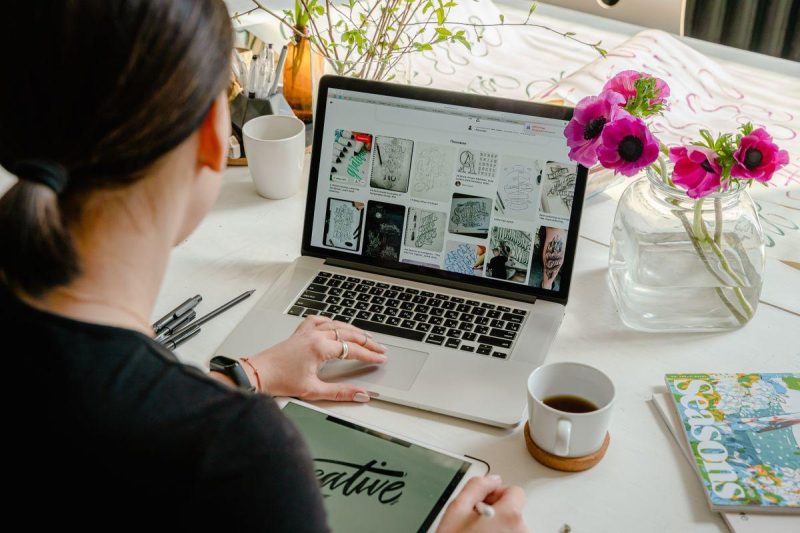 Professional using LinkedIn on a laptop in a modern office setting