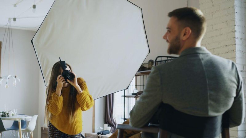 Professional photographer capturing a portrait indoors using softbox lighting