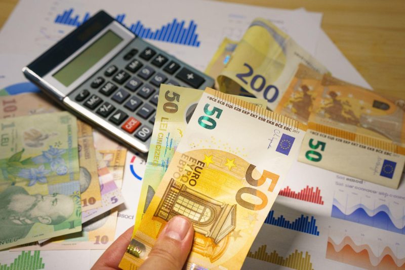 Euro banknotes and calculator on financial documents symbolizing business budget planning