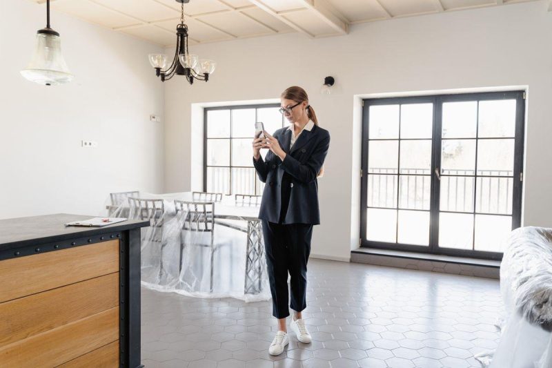Real estate agent taking photos inside a bright modern apartment for social media