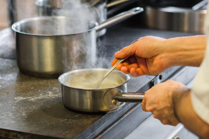 Professional chef cooking in a busy restaurant kitchen during service