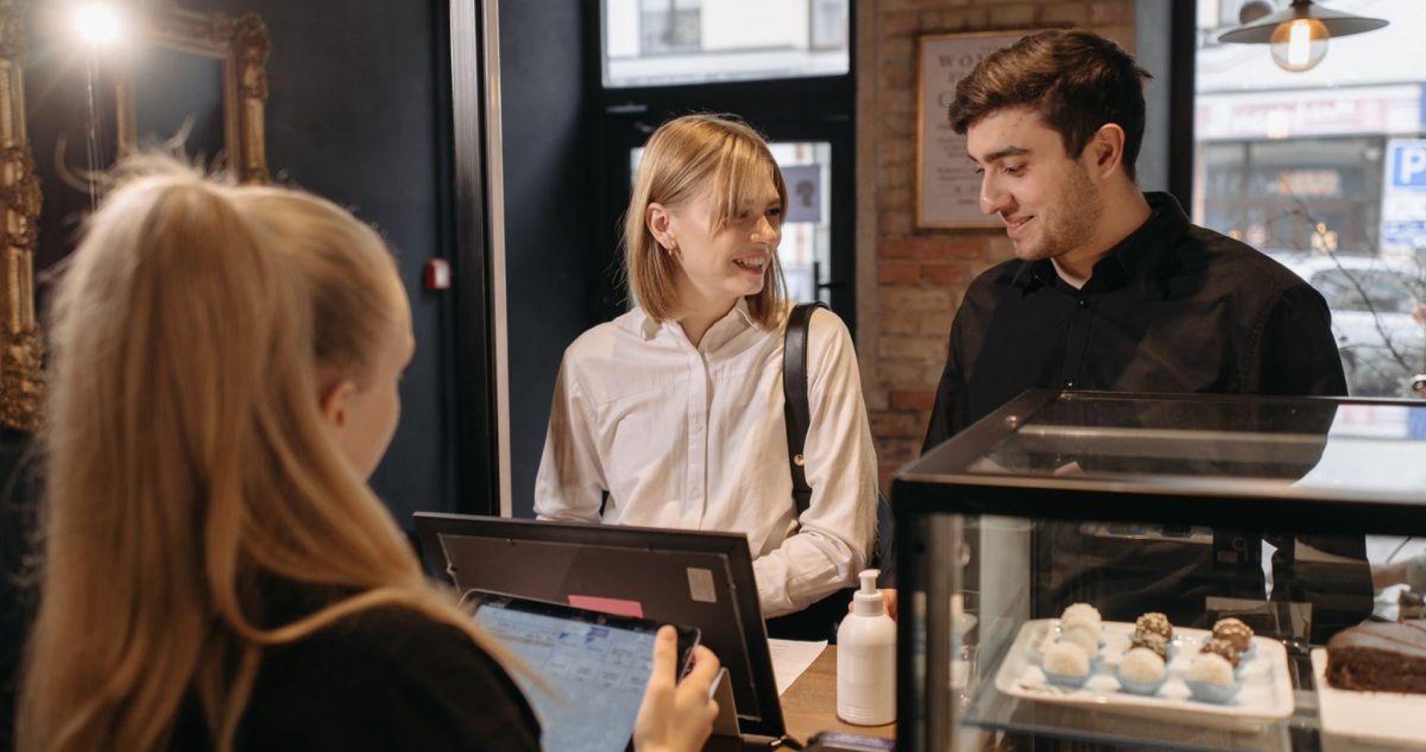 Small business barista interacting with a customer at the counter, representing social media customer service