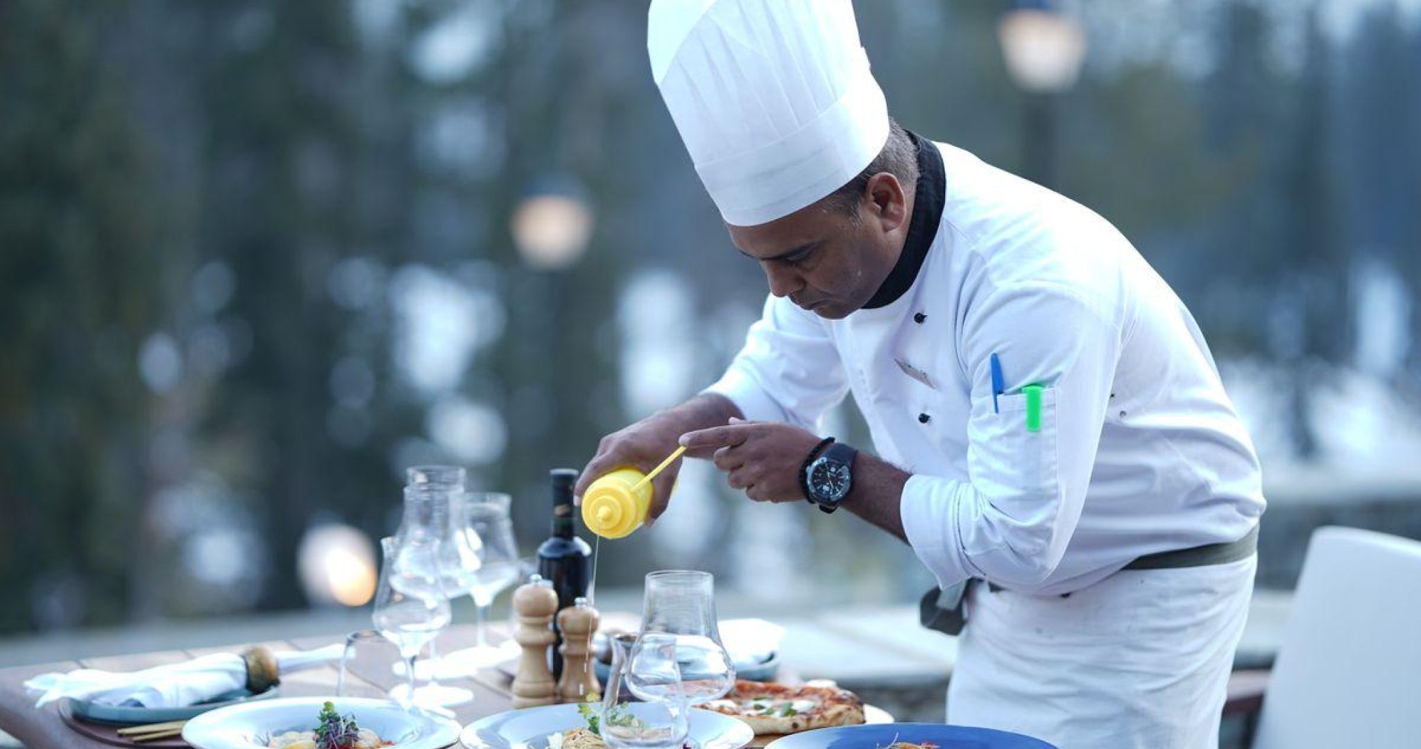 Chef carefully plating a gourmet dish in a professional restaurant kitchen
