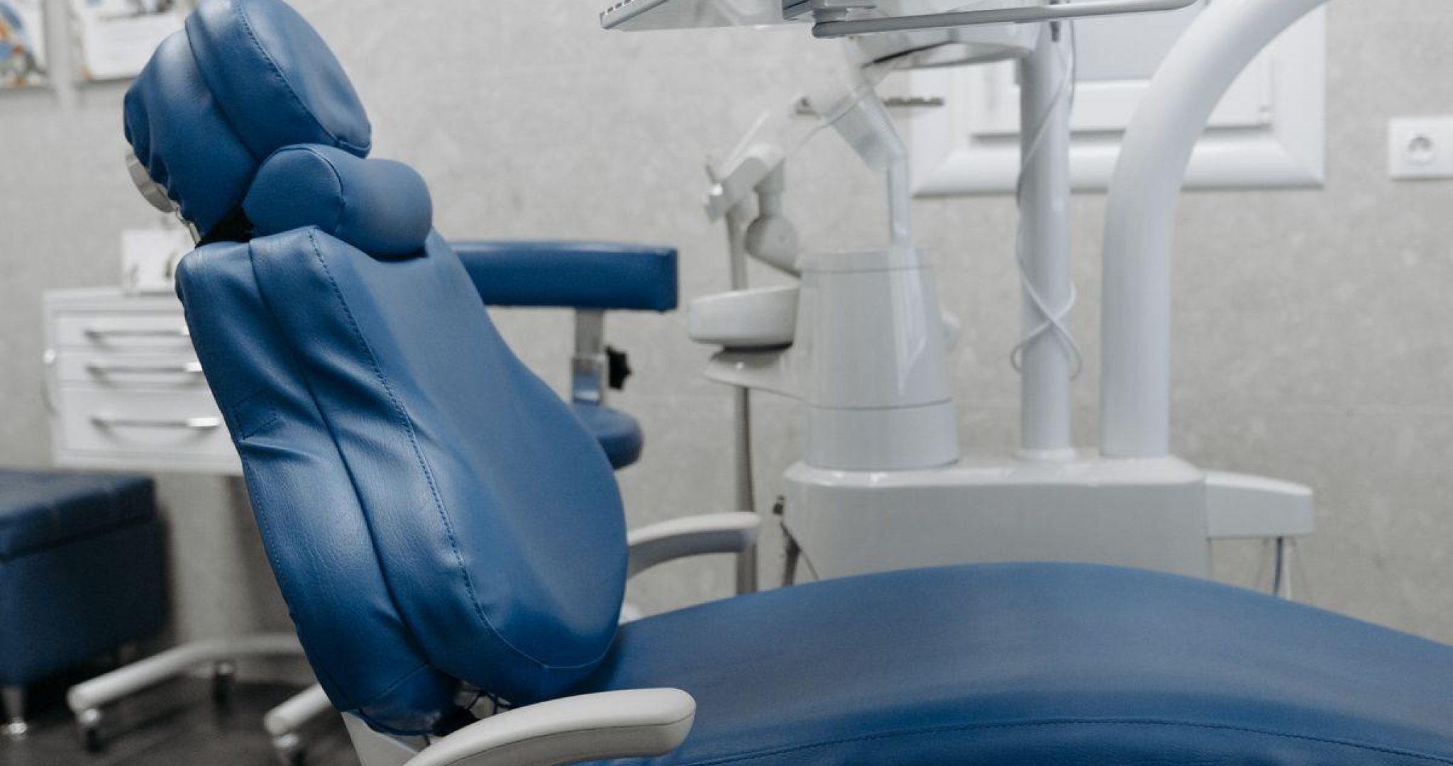 A clean dental office with state-of-the-art equipment and a blue dental chair, ready for patients