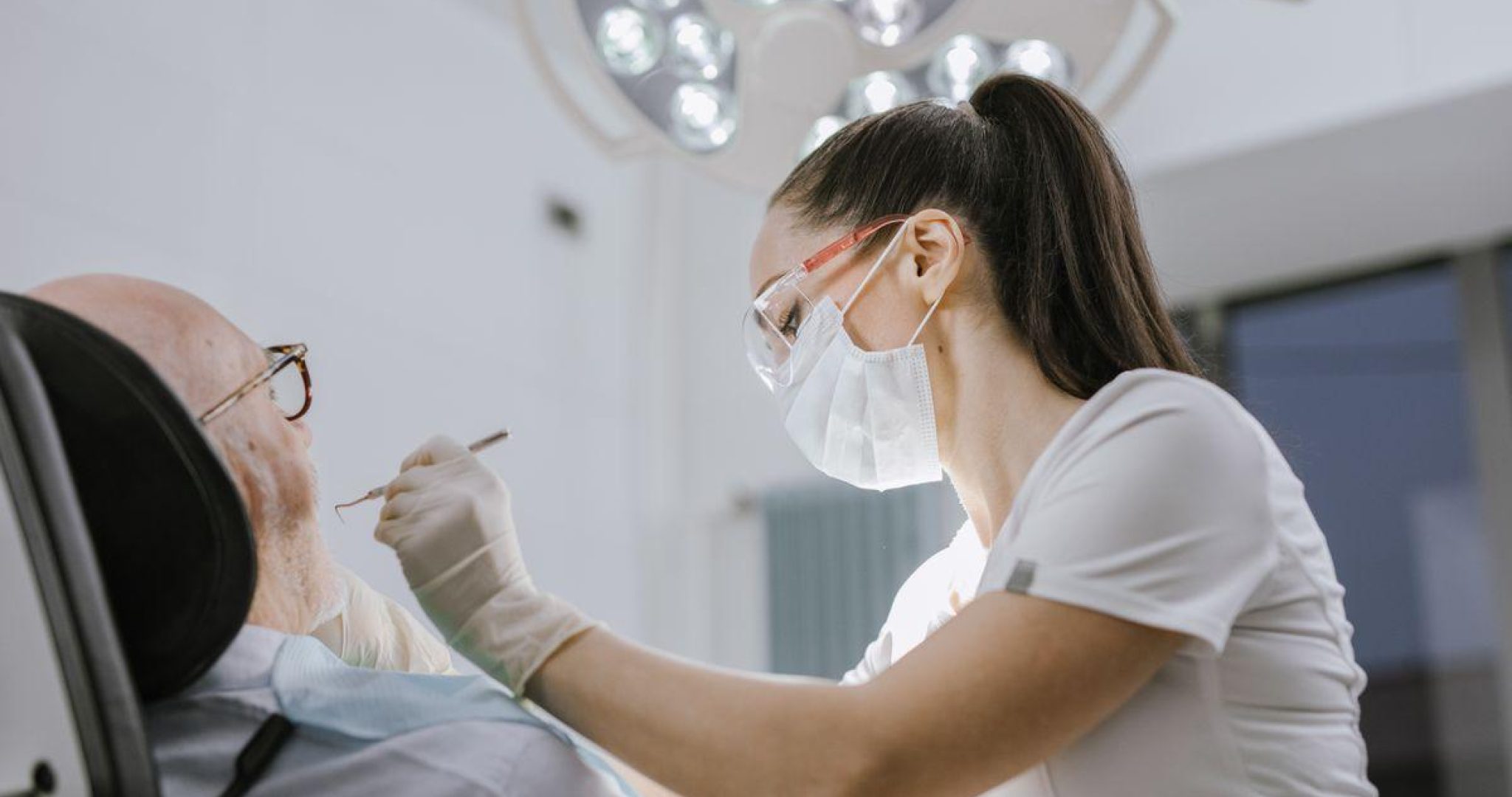 Female dentist working on a patient in a modern dental office with bright lighting