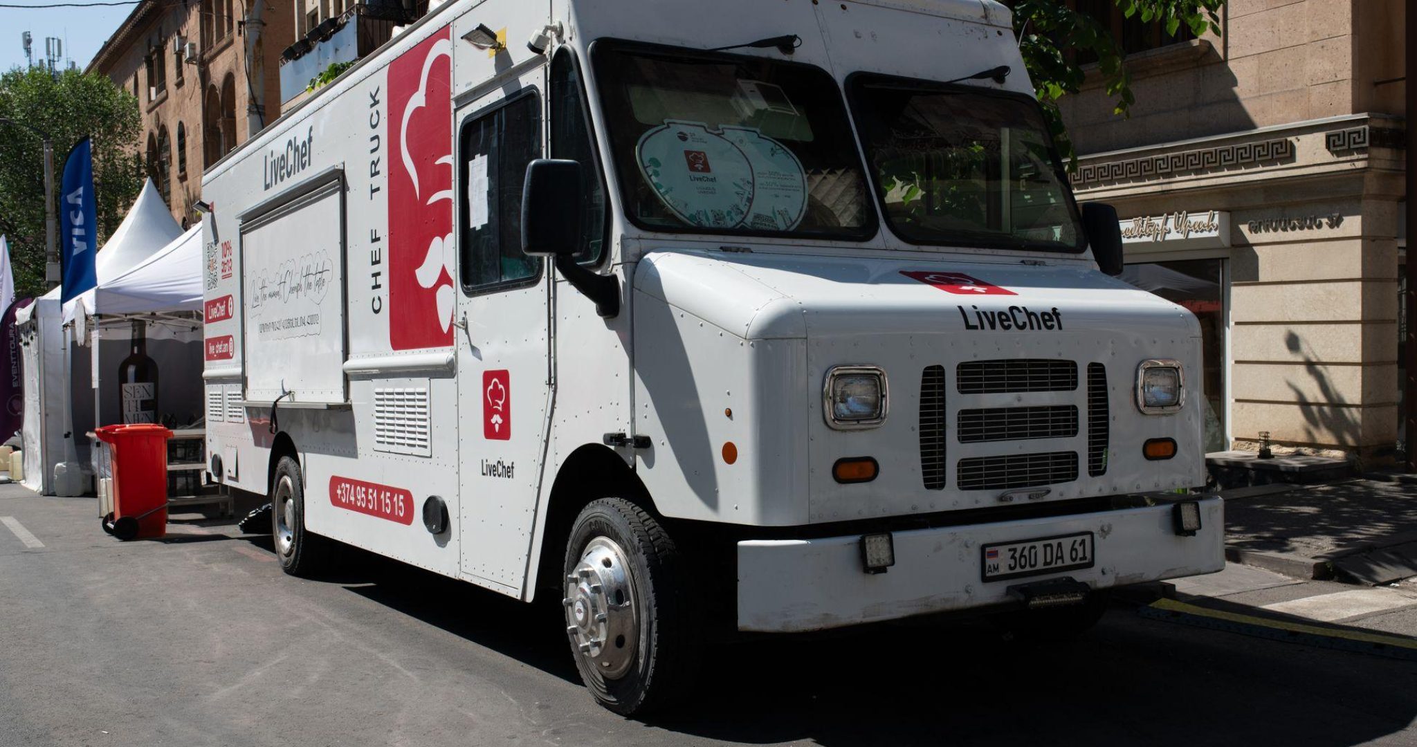 White food truck serving customers at a sunny street festival