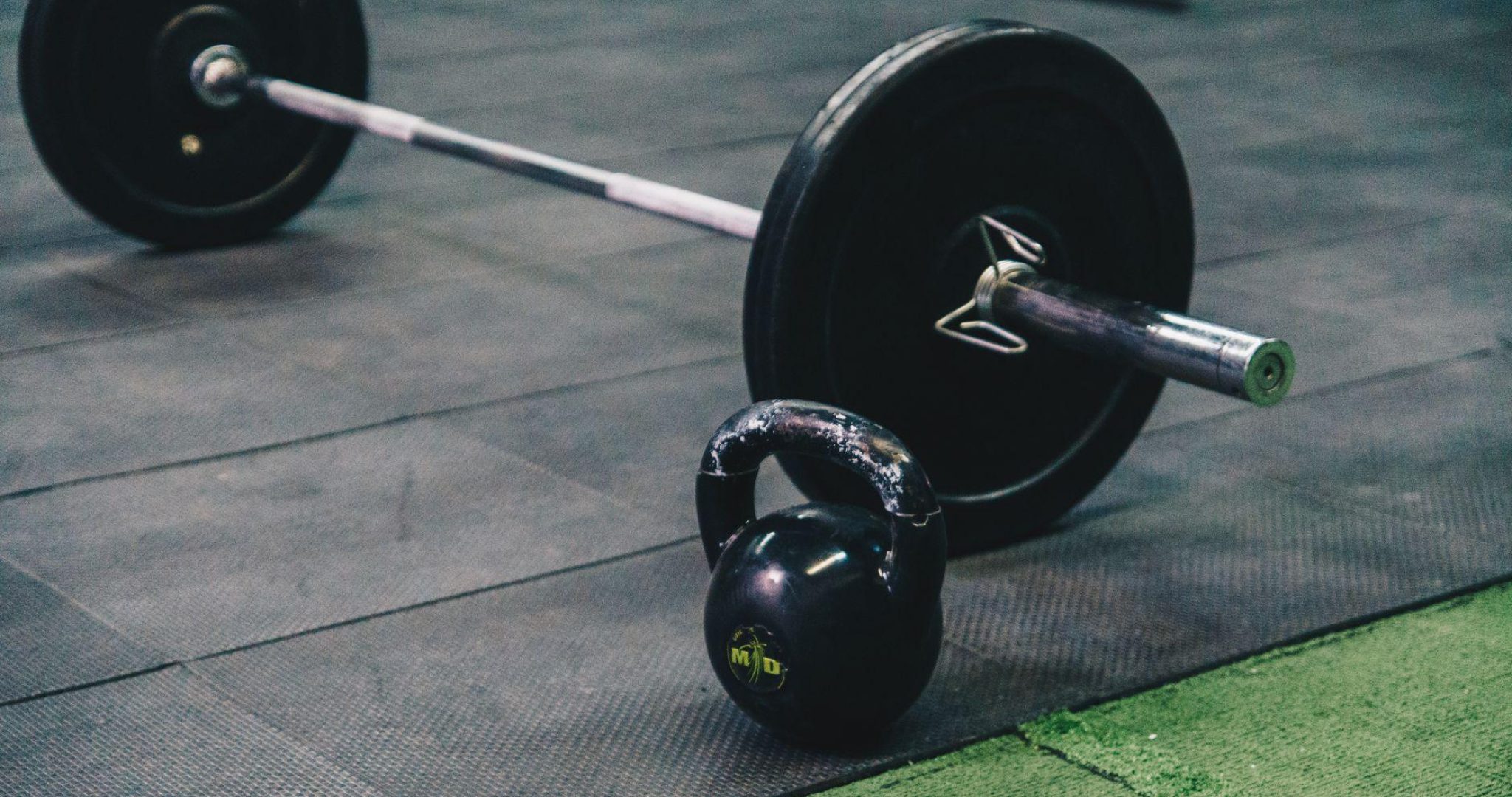 Barbell and kettlebell on gym floor for strength training
