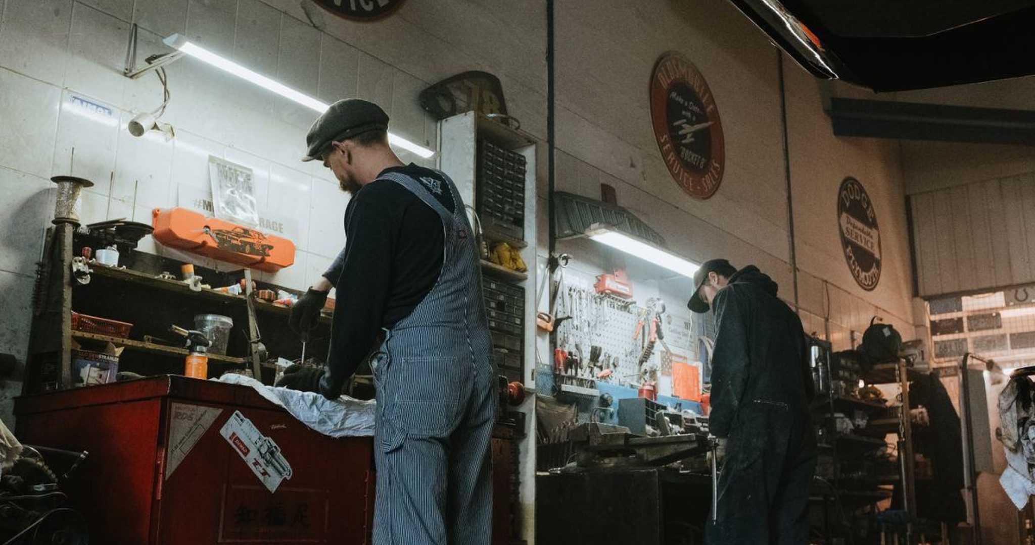 Two mechanics in a garage working on vehicle repair and maintenance