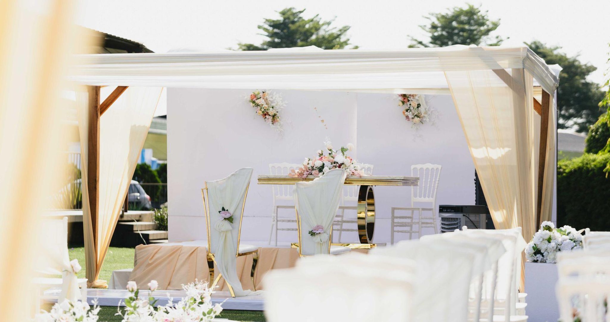 Beautiful outdoor wedding ceremony setting with white and pastel floral arrangements