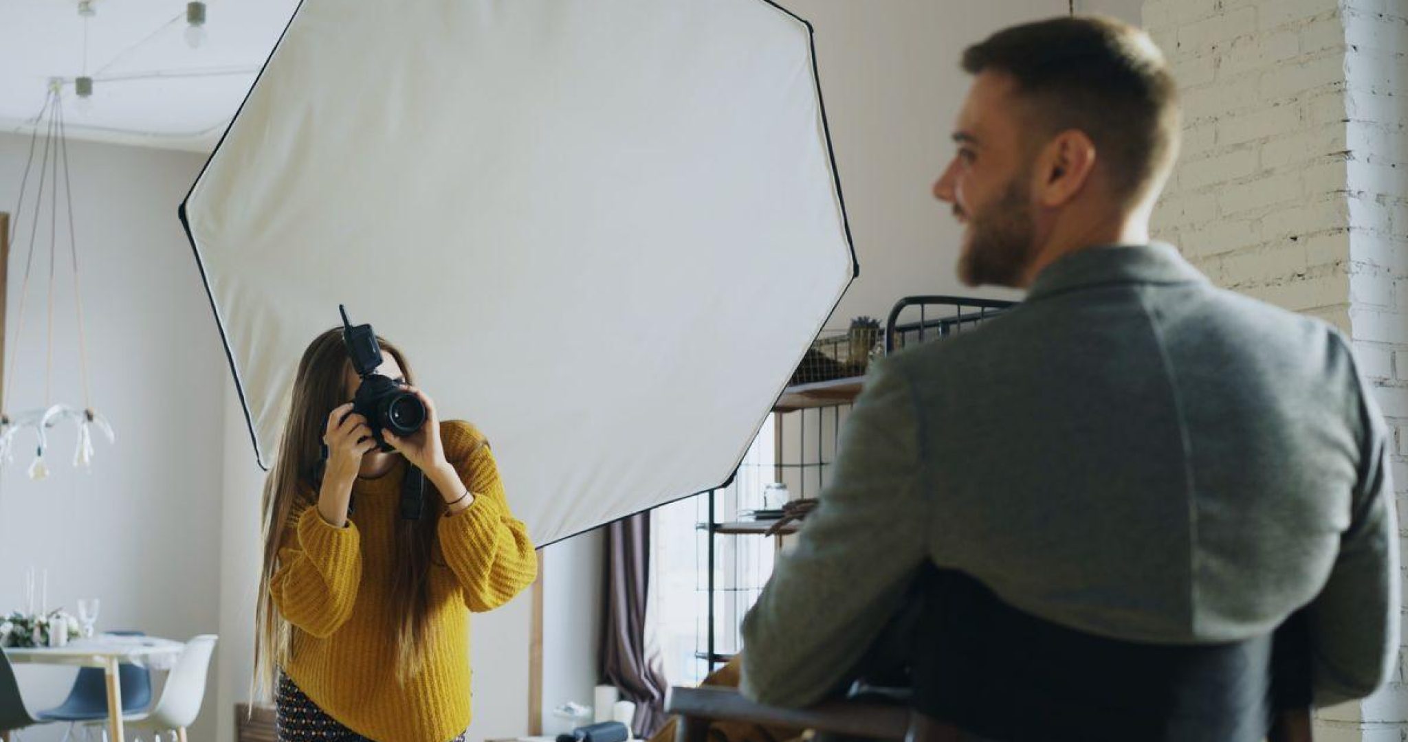 Professional photographer capturing a portrait indoors using softbox lighting