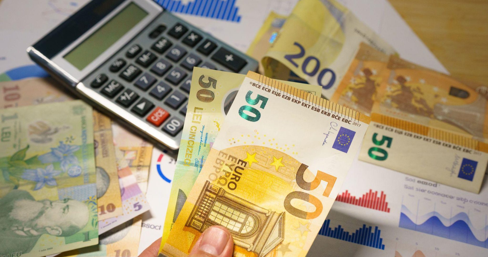 Euro banknotes and calculator on financial documents symbolizing business budget planning