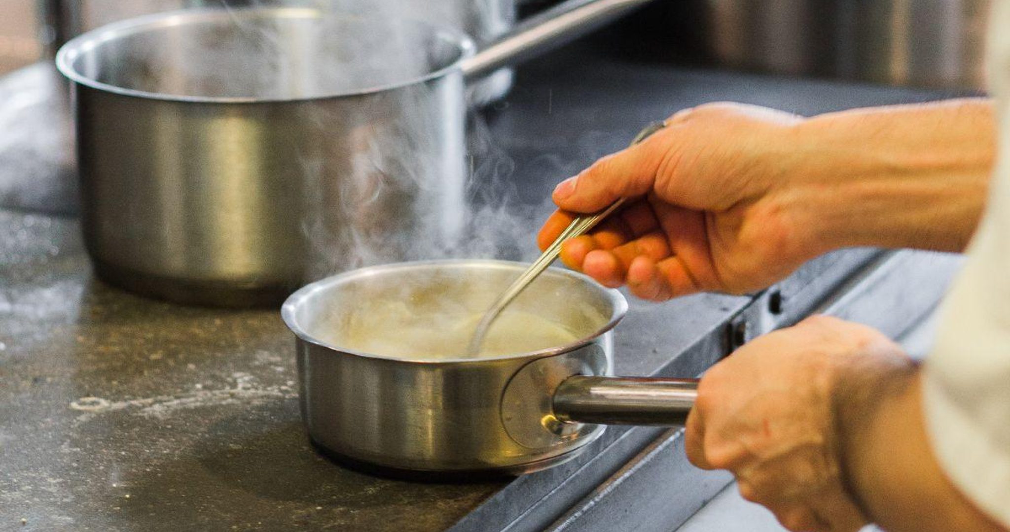 Professional chef cooking in a busy restaurant kitchen during service