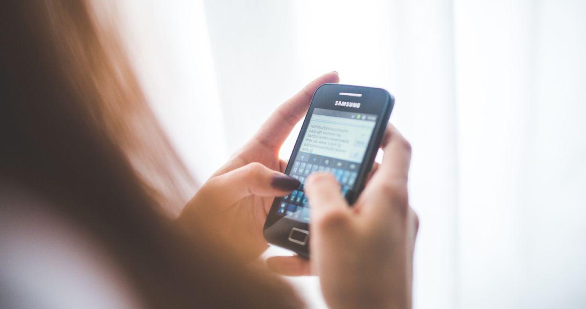 A person typing a message on their smartphone, representing WhatsApp business communication